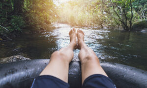 Local Man floating down Gore Creek after renting river tube from American Ski Exchange in Vail
